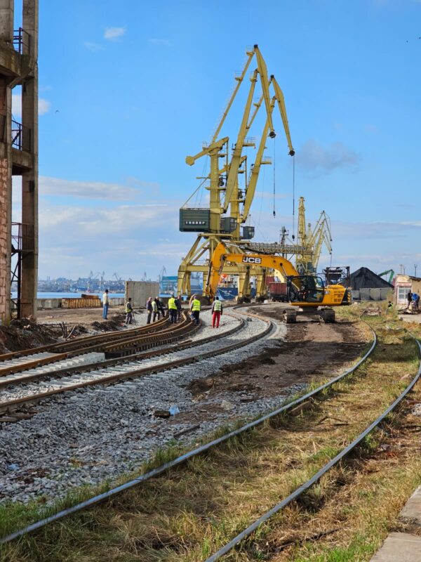 a construction site with cranes and train tracks