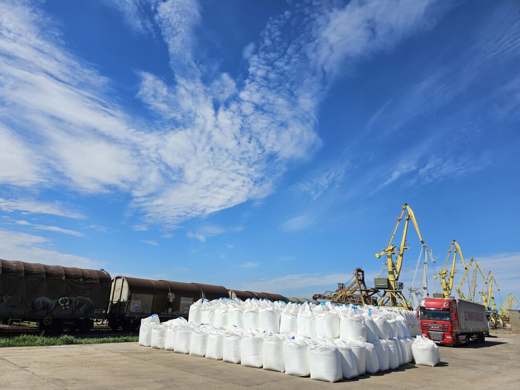 a large white bags of sand next to a train